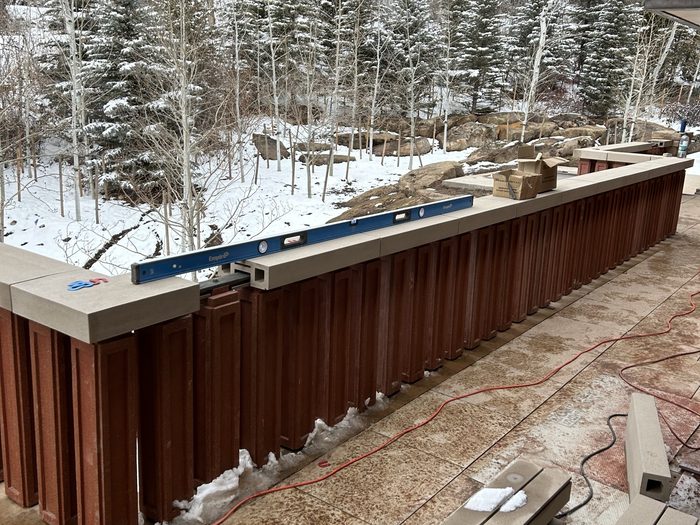 Leveling a baluster in the snow — install in progress.