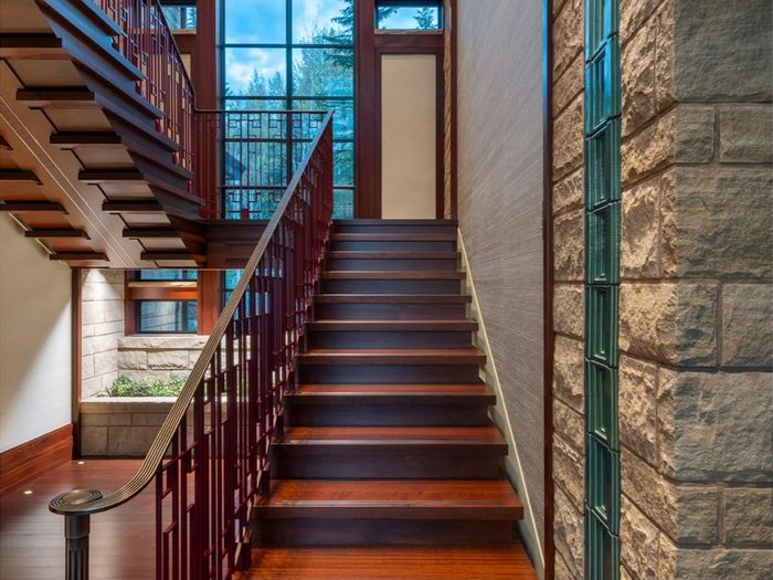 Finished interior stair — a vertical inset of green glass block set into the stone wall.