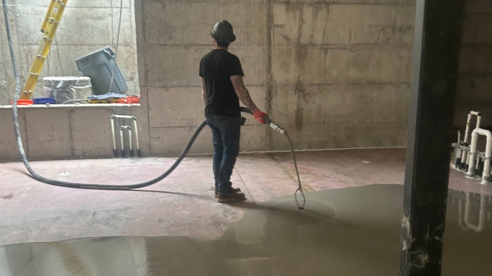 Self-leveler being placed across the lower level of a downtown Aspen build