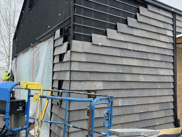 Setting large-format panels from a scissor lift during a snowfall.