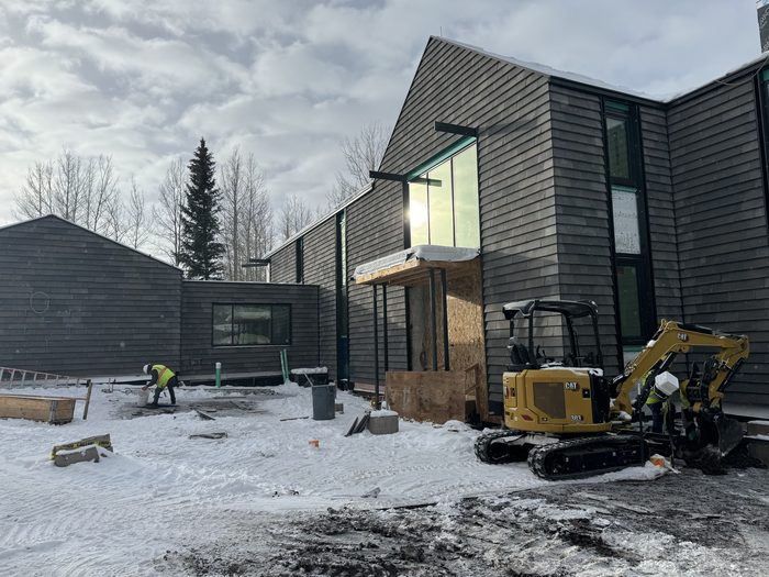 Primary facade largely clad, site still active through winter.