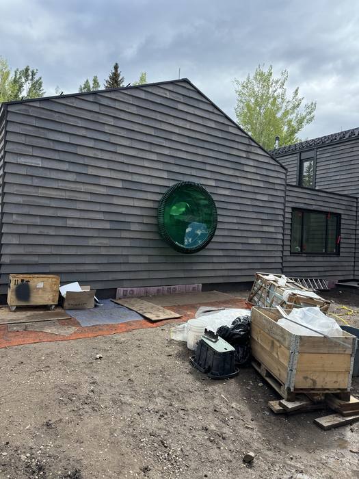 Round green glass window set into a steel frame.